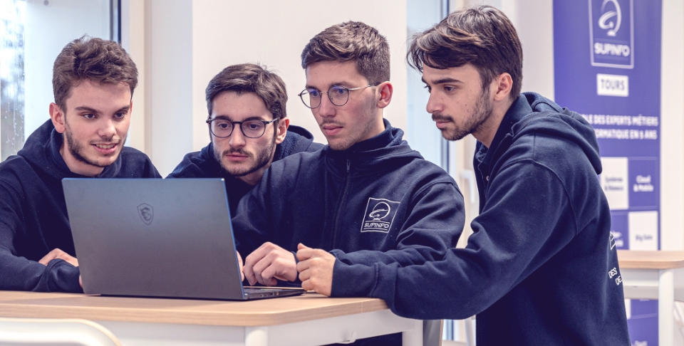 4 étudiants regardant un ordinateur